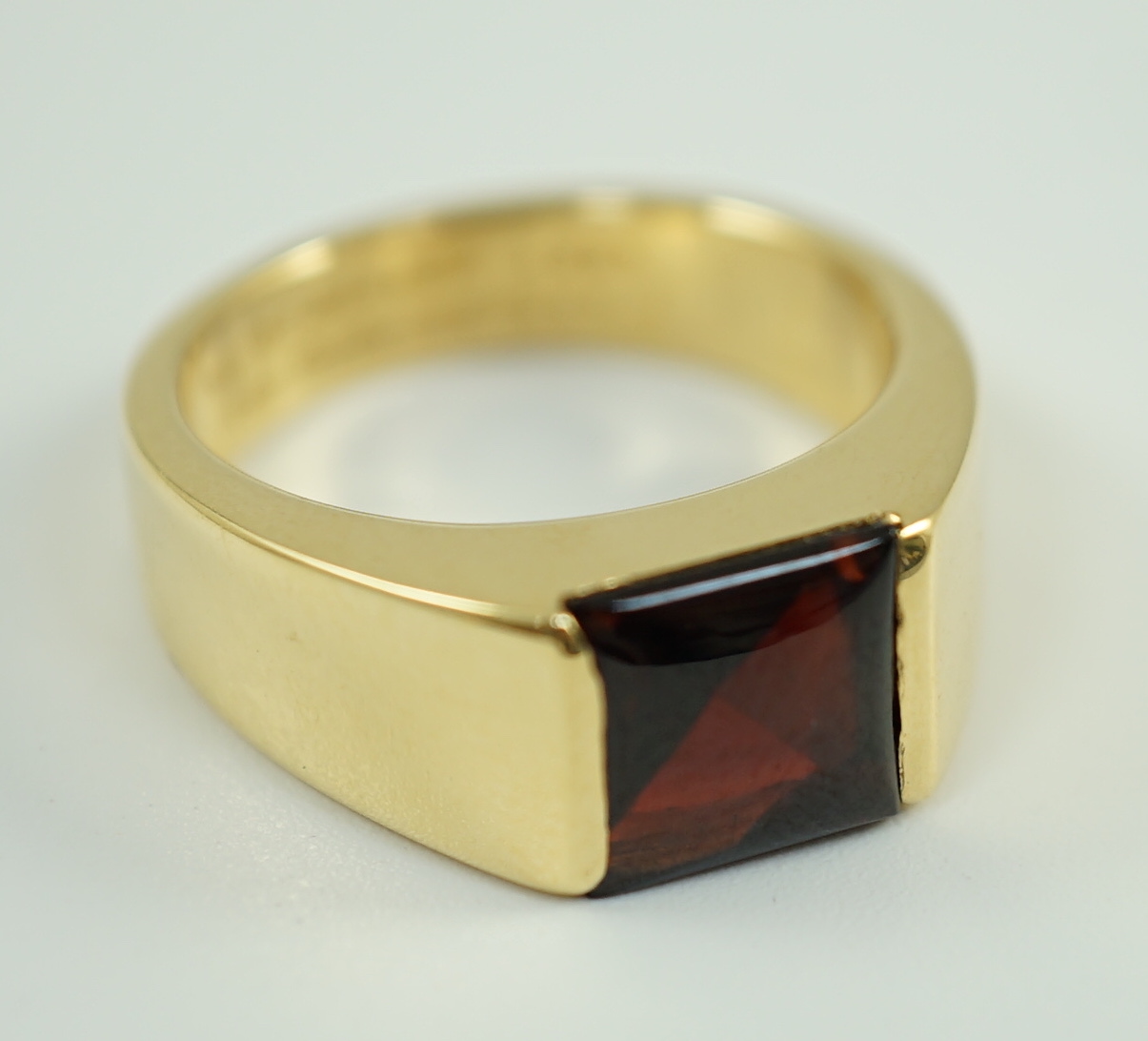 A gentleman's 1990's Cartier 18ct gold and gypsy set garnet ring